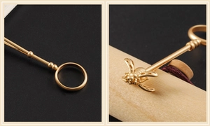Detailed macro shot of a golden bee ring cigarette holder with fine carved wings