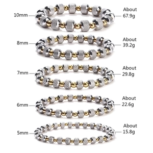 Two-tone stainless steel beaded bracelet stack in gold and silver textured grid finish