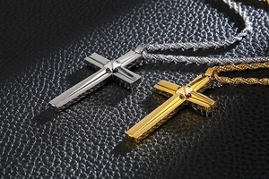 Detail view of silver and gold double-layered cross pendants on twisted steel chains
