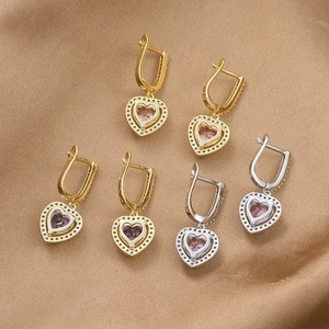 Elegant heart zircon earrings in gold and silver finish on silk background