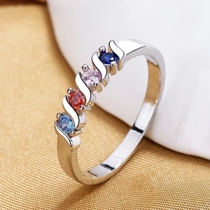 Detailed macro shot of a silver leaf ring featuring four colorful zircons in a wavy setting