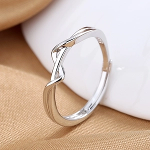 Vista macro de anillo plateado con diseño de onda trenzada y banda abierta ajustable