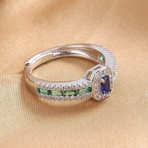Vintage silver ring with oval blue sapphire zircon and emerald side stones on satin