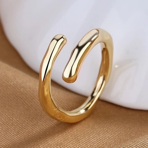 Macro detail of minimalist gold heart-shaped adjustable ring with fluid organic design