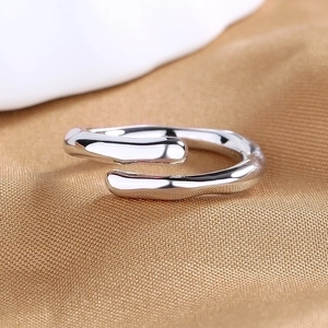 Silver liquid metal open ring with minimalist geometric punk style on fabric background