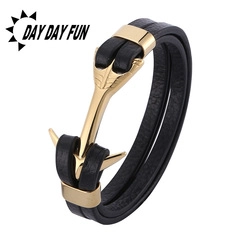 Detail view of double-layer black leather bracelet with polished golden anchor clasp