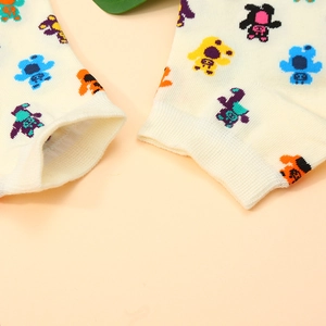 Close-up of cream knit ankle socks featuring colorful mini bear patterns on cotton fabric