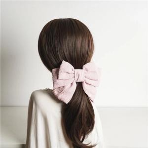 Pink triple-layered large bow hair clip with wrinkled texture shown from the back view