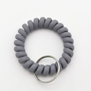 Detail of dark gray matte spiral wrist keychain with flexible elastic texture and metal ring
