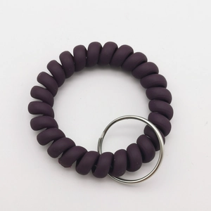 Macro shot of dark purple spiral wristband keychain with a polished silver metal ring