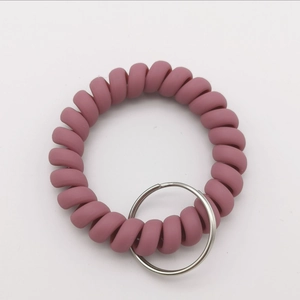 Detail of dusty pink matte spiral wrist keychain with durable metal ring and flexible cord