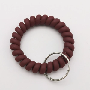 Detail of wine red matte spiral key ring with durable metal flat split ring attachment