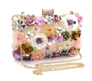 Detail of evening clutch bag featuring 3D floral petals, sequins and gold chain strap