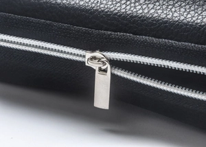 Detailed close-up of premium black lychee leather texture and smooth silver metal zipper