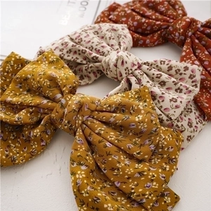 Three-layer knotted oversized floral bow hair clips in yellow, beige and red colors