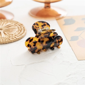 Detail showing high-quality tortoise shell pattern hair claw clip on marble background