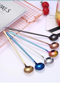 Cuillères à long manche en acier inoxydable multicolores sur une table élégante décorée