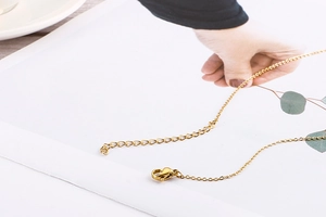 Close-up of golden lobster clasp and adjustable extension chain on elegant necklace