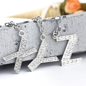Macro shot of silver metal alphabet keychains X Y Z with sparkling crystal rhinestones