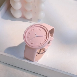 Close-up of pink minimalist watch with embossed 3D numerals and leather strap detail