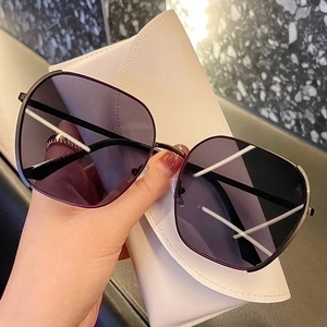 Oversized polarized sunglasses with purple gradient lenses and a white leather case