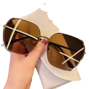 Chic oversized gold metal sunglasses with brown lenses and white leather pouch case
