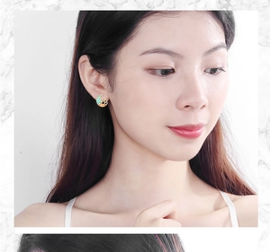 Close-up of model wearing stylish blue moon and gold star earrings on marble background