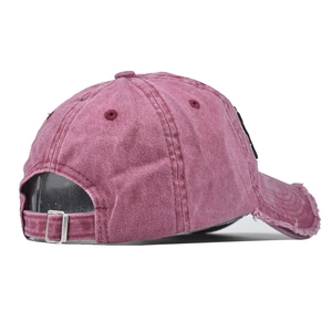 Detail of the distressed brim and metal buckle on this washed cotton baseball cap