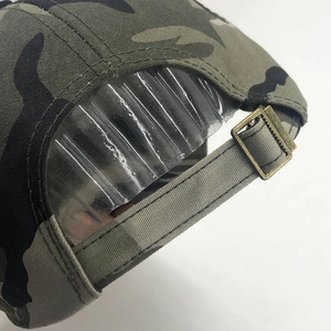 Detail of adjustable metal buckle and camouflage fabric texture on the baseball cap