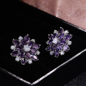 Macro shot of purple sunflower earrings with marquise cubic zirconia in a jewelry box