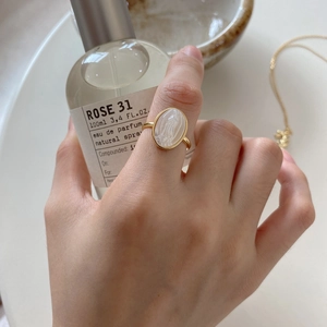 Close-up of gold 925 silver ring featuring an oval Maria shell cameo on a model's hand