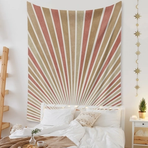 Detail of bohemian sunburst tapestry hanging over a bed with warm ambient lighting