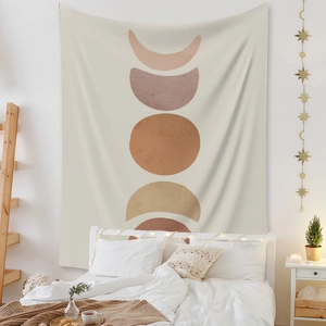 Bohemian moon phase tapestry in cream white fabric hanging over a cozy bedroom bed