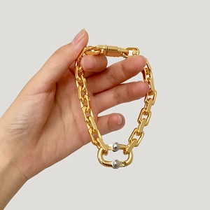 Detailed view of industrial gold chunky chain bracelet with sphere accents and spring clasp