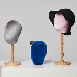 Elegant mannequin head stands in grey blue and pink with wooden bases for hat display