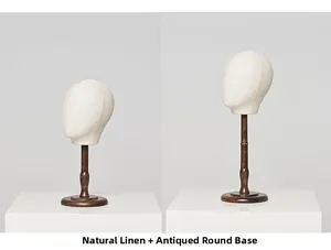 Detail of linen head mannequin with antique brown wooden base for hat and wig display