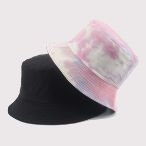 Close-up of cotton bucket hats featuring classic black and colorful tie-dye patterns