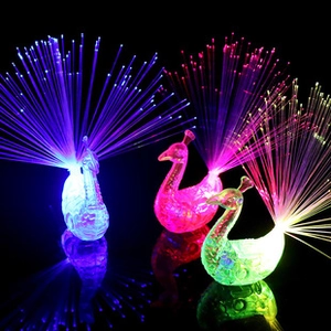 Three glowing LED peacock figurines with fiber optic tails in blue pink and green colors