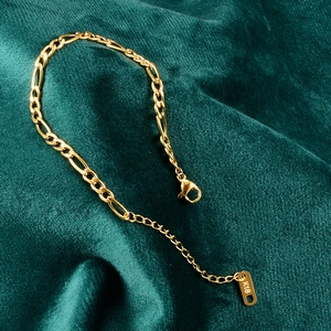 Pulsera minimalista de cadena Figaro en oro de 18K con extensión sobre terciopelo