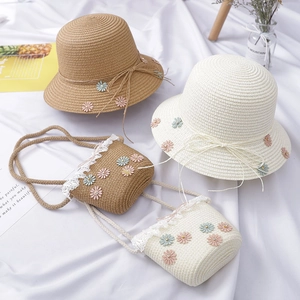 Detail of children's straw hat and crossbody bag set with daisies and lace trim