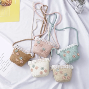 Detail of colorful children's straw bags with delicate lace trim and daisy floral accents