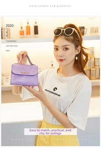Dettaglio borsa viola effetto coccodrillo con catena dorata e logo in metallo