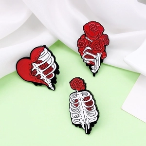 Gothic enamel pins set featuring skeleton hand with roses and ribcage heart design