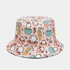 Close-up of pink bucket hat featuring cute hand-drawn bear and carrot cartoon patterns