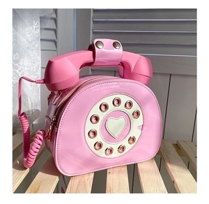 Detail view of pink vintage telephone bag with rotary dial and heart-shaped center