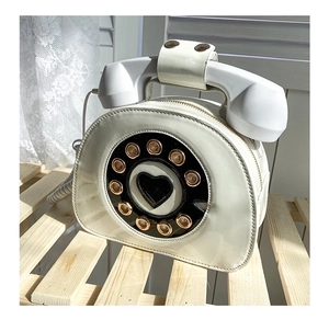 Detail of creative vintage telephone handbag featuring glossy finish and retro dial pad