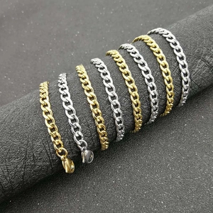 Classic gold and silver cuban link chain necklaces displayed on black textured background