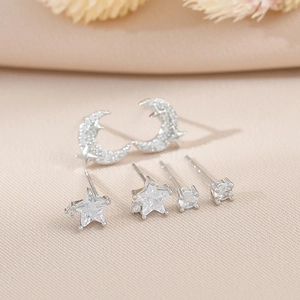 Macro shot of silver moon and star earrings set with cat eye stones and zircons