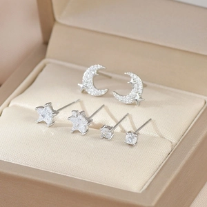 Macro view of silver star, moon and round stud earrings set with sparkling zircons