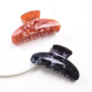 Elegant amber and blue marble pattern hair claws set on a ceramic plate display